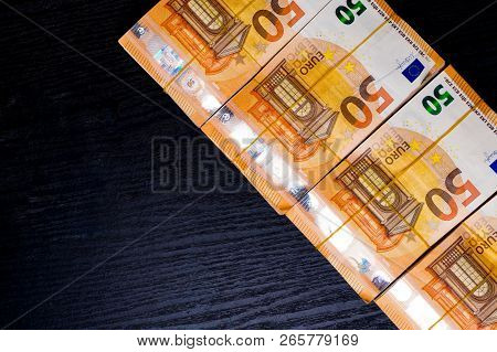 Pile Of 50 Real Euro Notes 50-euro Banknotes Under Rubber Band Isolated On Black. About 20000 Euros 