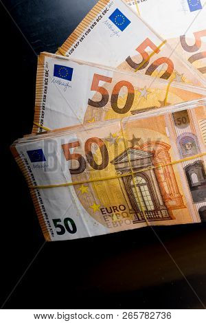 Pile Of 50 Real Euro Notes 50-euro Banknotes Under Rubber Band Isolated On Black. About 20000 Euros 