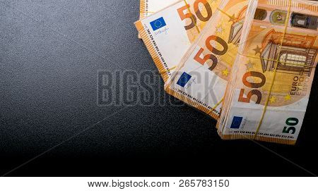 Pile Of 50 Real Euro Notes 50-euro Banknotes Under Rubber Band Isolated On Black. About 20000 Euros 