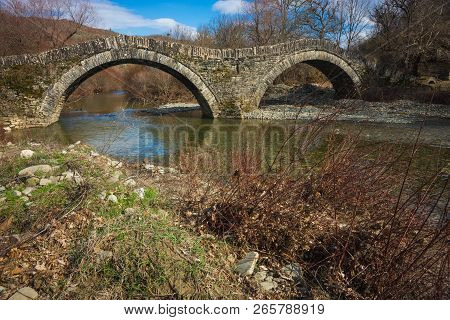 Ancient Snone Bridge Over River In Zagorohoria, Greece