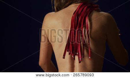 The Back Of An Unrecognizable Thin Girl With A Thin Waist. The Woman Whips Herself On The Back With 