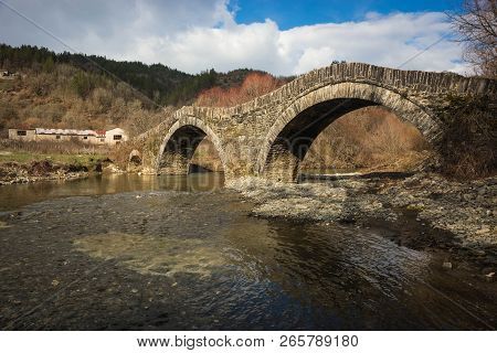 Ancient Snone Bridge Over River In Zagorohoria, Greece