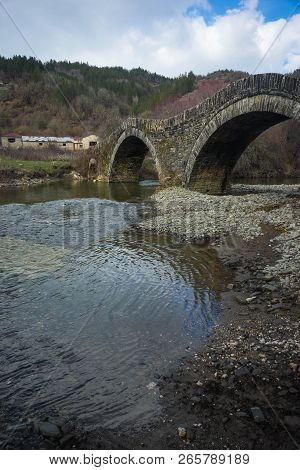 Ancient Snone Bridge Over River In Zagorohoria, Greece