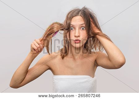 Amazed Young Woman Stands And Looks On Camera. She Holds Brush In One Hand. She Uses Another One For