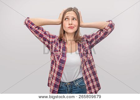 Young Blonde Woman Stands And Poses. She Looks Up To Left. Moel Holds Hands On Hair. She Looks Caref