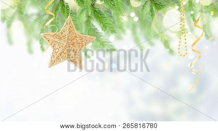 Golden Christmas Star Hanging On Christmas Evergreen Tree