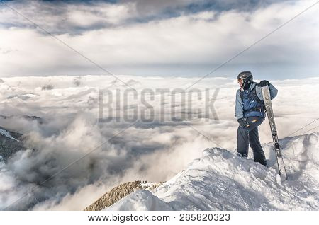 Skier Stay With Skis On Big Rock On Mountains Backdrop. Bansko, Bulgaria
