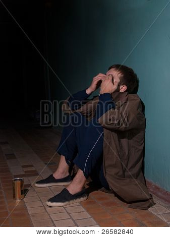 Homem sem-teto, sentado no chão