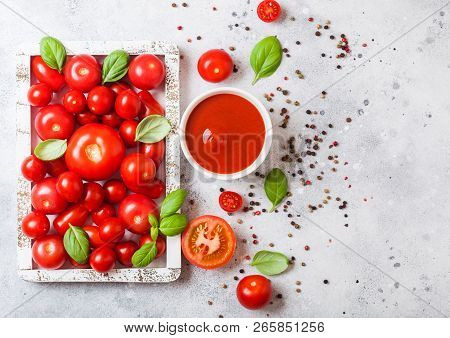 Glass Of Fresh Organic Tomato Paste With Fresh Raw Tomatoes Basil And Pepper In Box On Stone Backgro