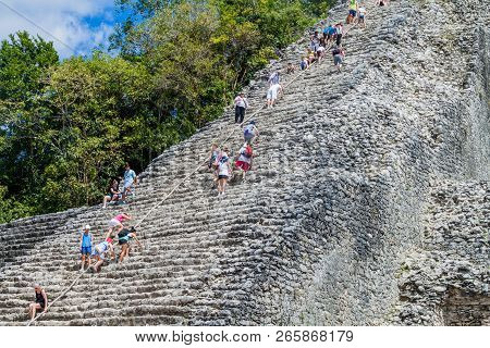 Coba, Mexico - March 1, 2016: Tourist Climb The Pyramid Nohoch Mul At The Ruins Of The Mayan City Co