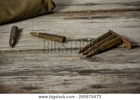Disassembled Clip With Cartridges 7, 92 X 57 - Rustic Ammos And Poncho Lies On The Wooden Background