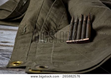 Holder With Cartridges 7, 92 X 57 - Rustic Ammos And Poncho Lies On The Wooden Background