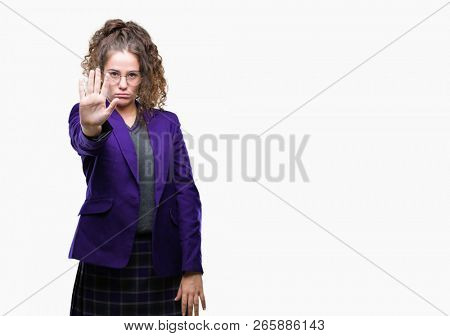 Young brunette student girl wearing school uniform and glasses over isolated background doing stop sing with palm of the hand. Warning expression with negative and serious gesture on the face.