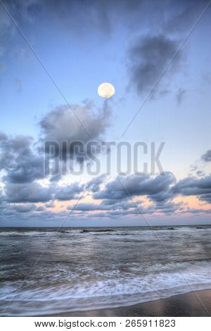 Moonset Over The Ocean At Vanderbilt Beach At Sunset
