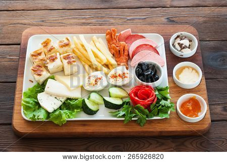 Mediterranean Snacks Set On A Wooden Board. Olives, Feta Cheese,