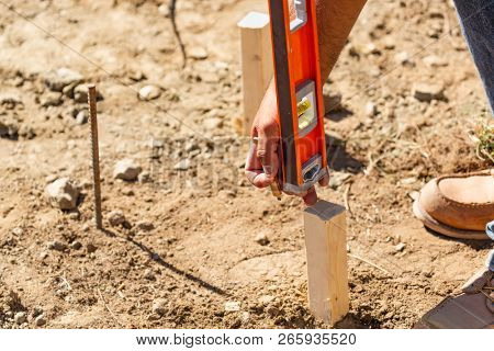 Worker Using Level At Constrcution Site