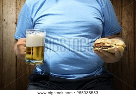 Fat Man With Beers And Hamburger On His Hand Over Wooden Wall Background