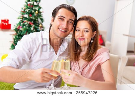 Young couple celebraring christmas with champagne