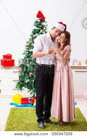 Young couple celebraring christmas with champagne