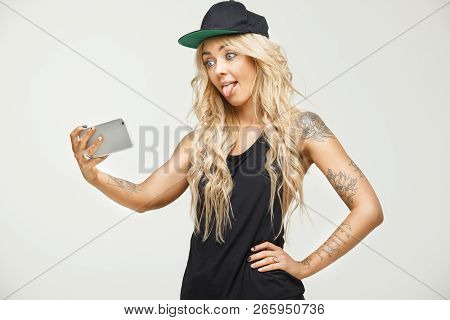 Cute Blonde Girl Grimaces Making Selfie On Phone Over White Isolated.