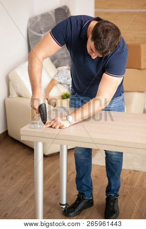 Man Assembling Furniture In Their New Flat