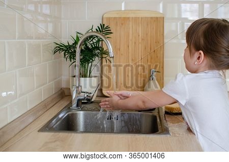 Adorable Toddler Girl Washing Her Hands Under Kitchen Sink. Little Girl Having Fun With Water. Hygie