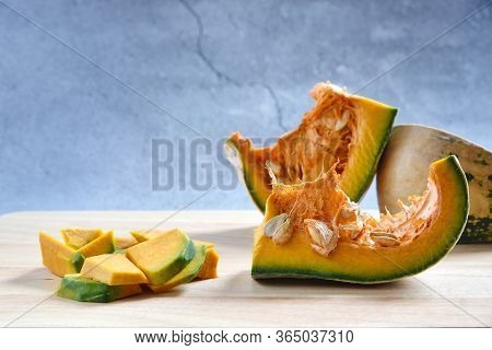 Pumpkin Slices Diced And Pumpkin Porridge On A Wooden In Dark Background. Concept Cookery Chopped Pu