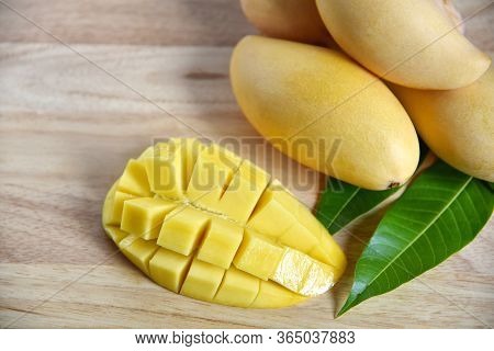 Mango. Tropical Fruits On A Wooden Background. Fresh Beautiful Mango Fruit With Sliced Diced Mango C
