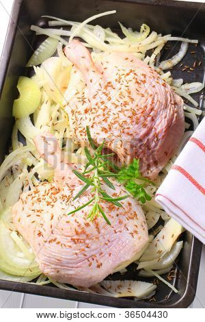 Twee benen kip met uienringen op een zwarte frier