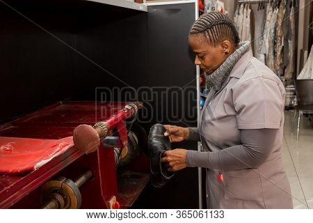 Johannesburg, South Africa - May 25, 2015: African Woman Working Inside A Shoe Repair And Dry Cleane
