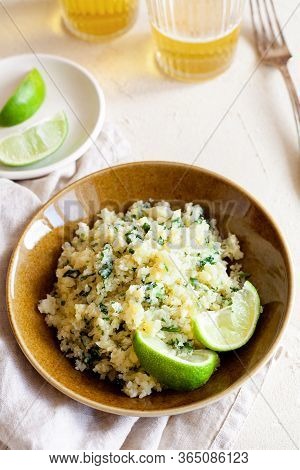 Cauliflower Low-carb Rice Or Couscous With Chopped Cilantro And Lime In A Brown Bowl Top View