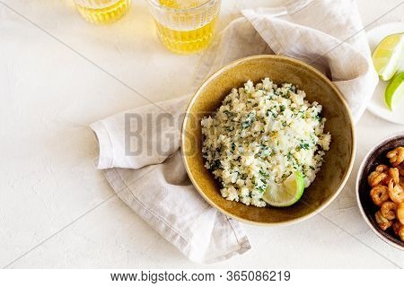 Cauliflower Low-carb Rice Or Couscous With Chopped Cilantro And Lime In A Brown Bowl On White Backgr