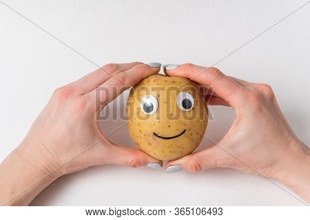Hands Holding Raw Potatoes With Googly Eyes And Smile. Vegetables With Funny Face.