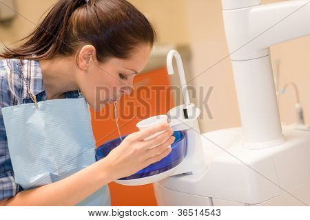 Dental patient woman spit water after treatment at stomatology clinic