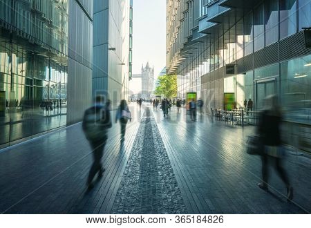 business people, modern buildings and Tower Bridge, London, UK