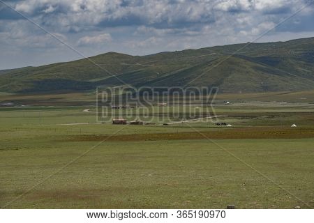 Sunlight Shines Through The Dark Clouds On The Qilian Mountain Meadow