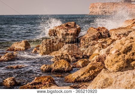 Splitting Waves Against Picturesque Rocks In The Sea