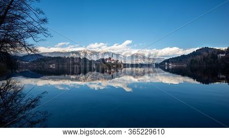 Bled Lake In Slovenia With Blue Sky And Clouds, Apls Mountains Behind. Traveling At Slovenia, Landsc