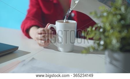 Office Worker Pour Water From A Kettle. Slowmotion