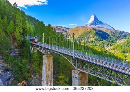 Zermatt, Switzerland. Gornergrat Red Tourist Train On The Bridge And Matterhorn Peak Panorama In Swi