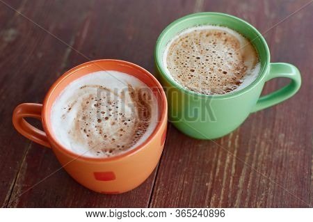 Two Cups Of Fragrant Cappuccino On A Wooden Roofing Paper. Airy Milk Foam Of A Hot Drink. Coffee Dri