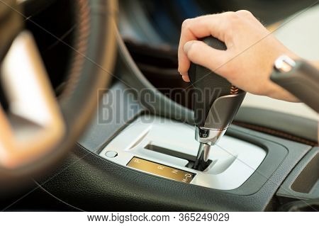 Close Up Of Woman Driver Holding Her Hand On Automatic Gear Shift Stick Driving As Car.