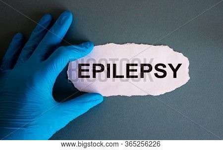 Hand In Blue Glove With White Small Paper. Concept Word Epilepsy.