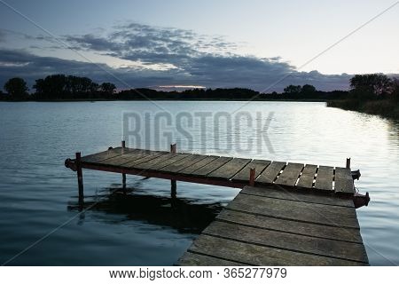 Fishing Pier Made Of Boards On The Lake And Gark Clouds After Sunset, Stankow, Poland