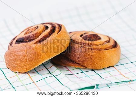 A Cinnamon Bun On A Napkin On White