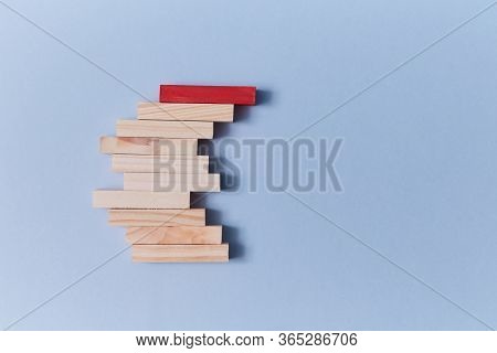Stack Of Wooden Blocks With Red Plank On Top. Not Like Everyone. Uniqueness And Originality. Stand O