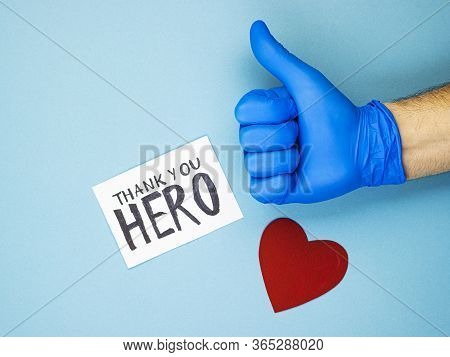 A Hand With A Raised Thumb In A Medical Glove, A Red Heart And The Inscription Thank You To The Hero