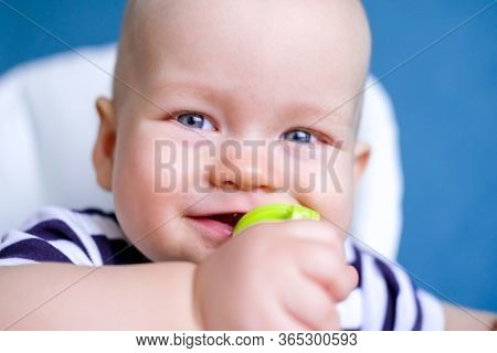 Baby Food. Close Up Little Smiling Caucasian Child With Nibbler Fruit Tracker In Mouth Eating Health