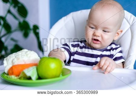 Baby Food. Little Displeased Caucasian Child Pushes Plate Away From Himself With Healthy Food On Hig