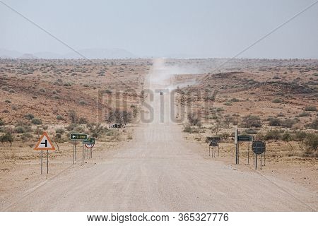 Cars Kick Up Dust On The C35 Gravel Road In Tsiseb Region, Namibia, Africa